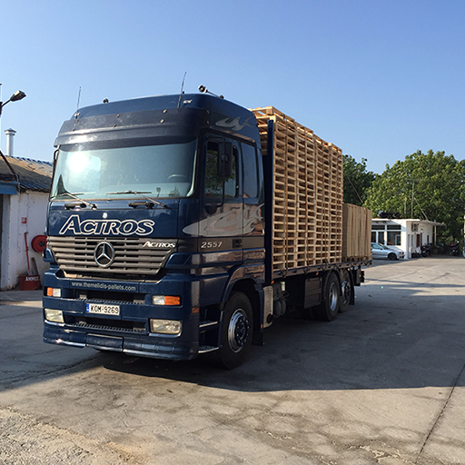 A worker inspecting a wooden pallet for quality control.